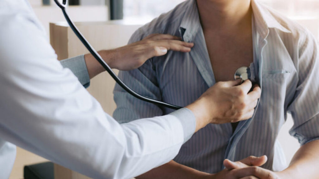 Image of a medical professional using a stethoscope to listen to a male patient's heart